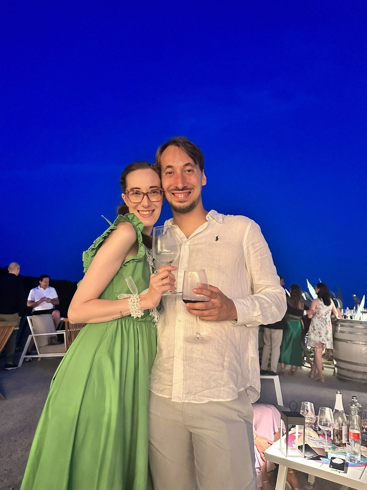 Laura e Marcello brindano insieme in una sera d'estate